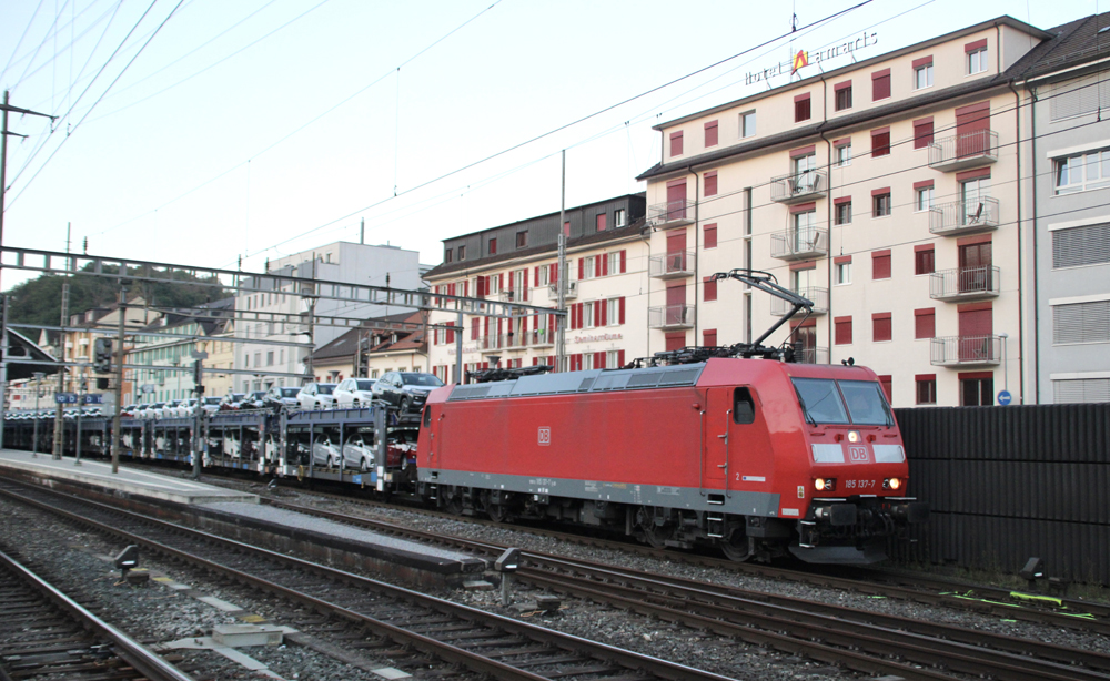 Red electric locomotive with bilevel auto racks