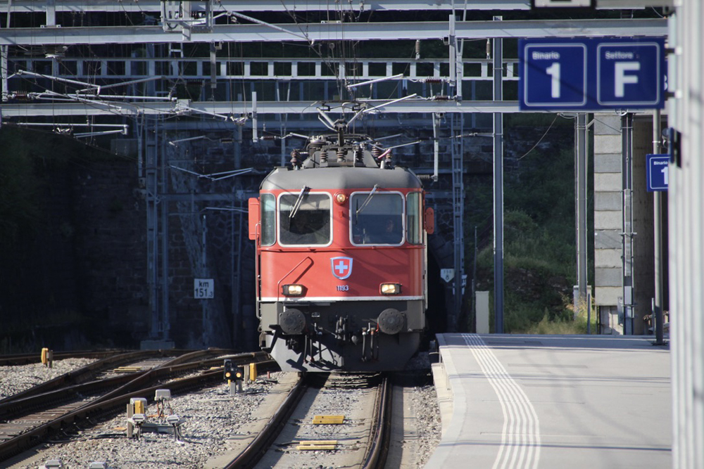 Red electric locomotive approaches station
