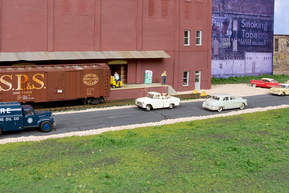 Red brick industry, boxcar, street with cars, green lawn