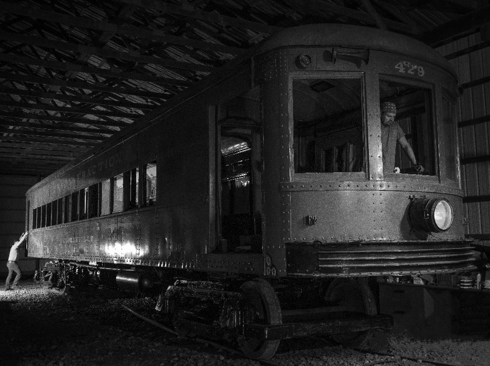 black and white photo of trolley car in shop.