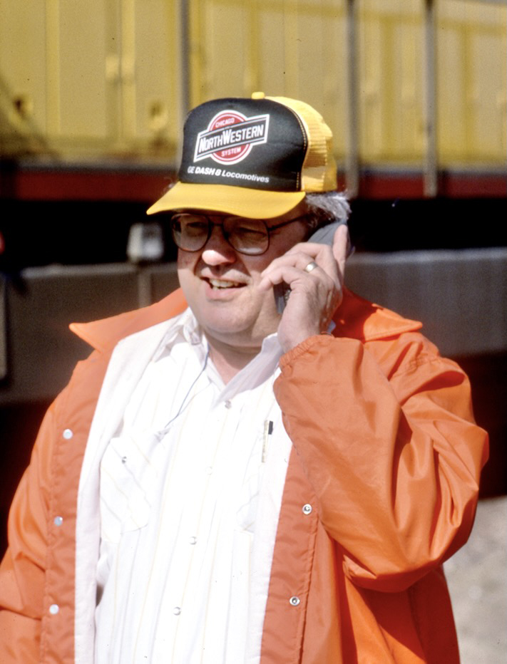 Man in orange jacket speaking on cell phone