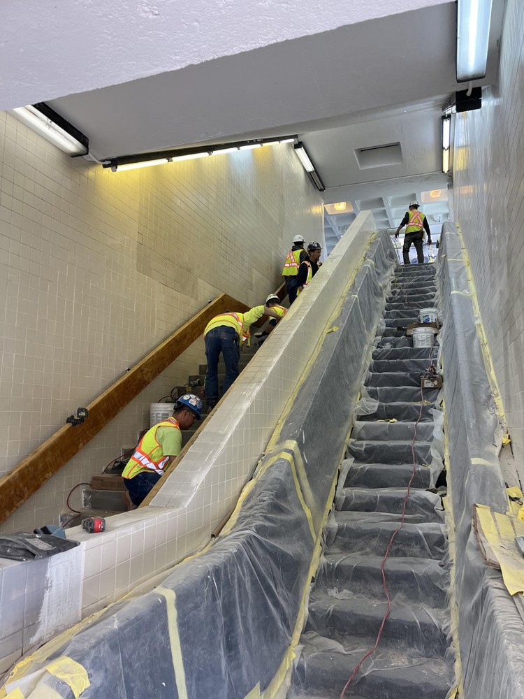 Construction workers in stairwell of transit station