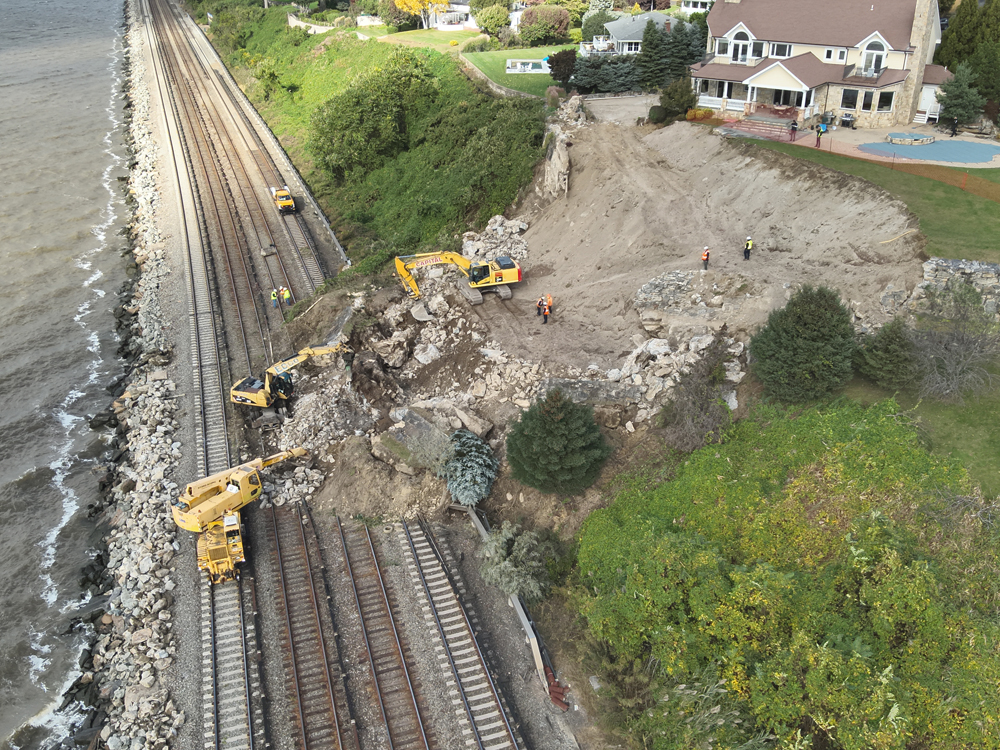 Earthmovers at work to clear mudslide on railroad tracks