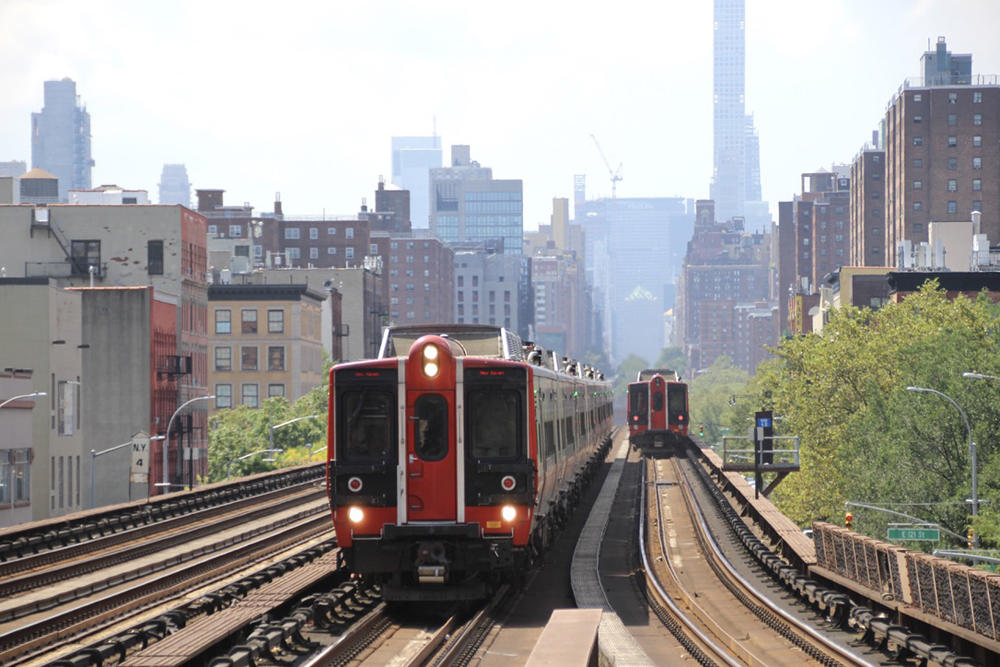 Electric multiple-unit trains meet with New York City skyline in background