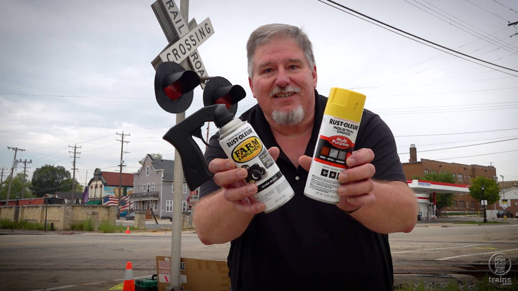 Man holding two cans of spray paint. Trains LIVE — Rail safety week 2023