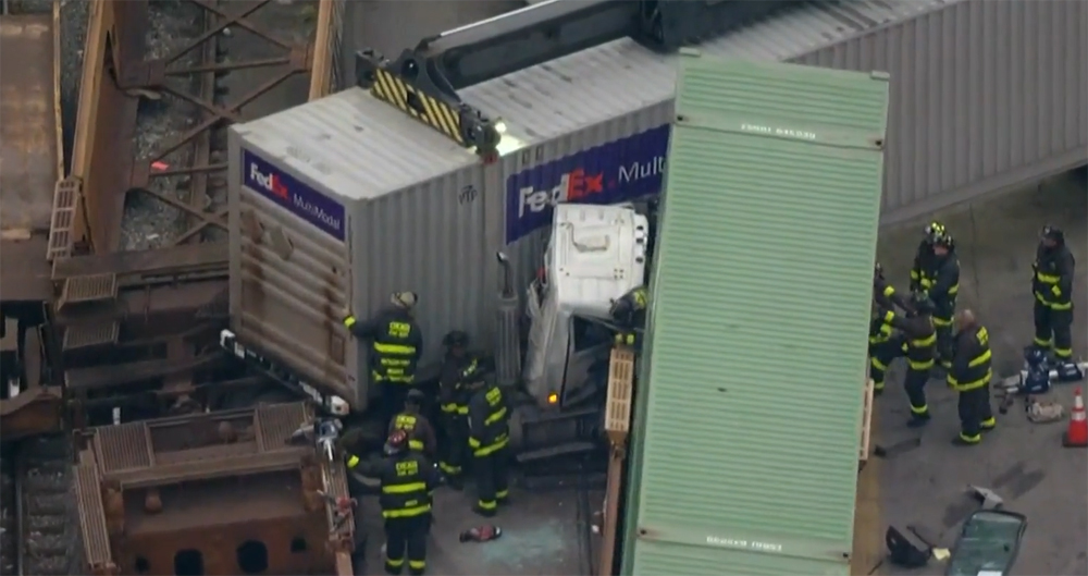 Firefighters attending to truck cab smashed by railroad car