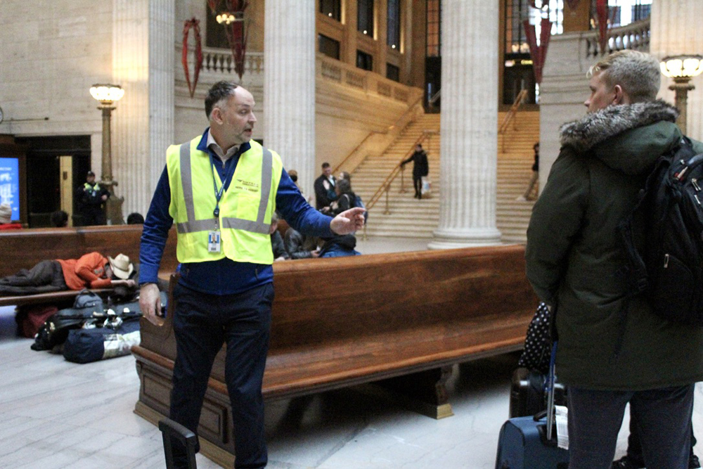 Man in hi-viz vest offering directions at Chicago Union Station