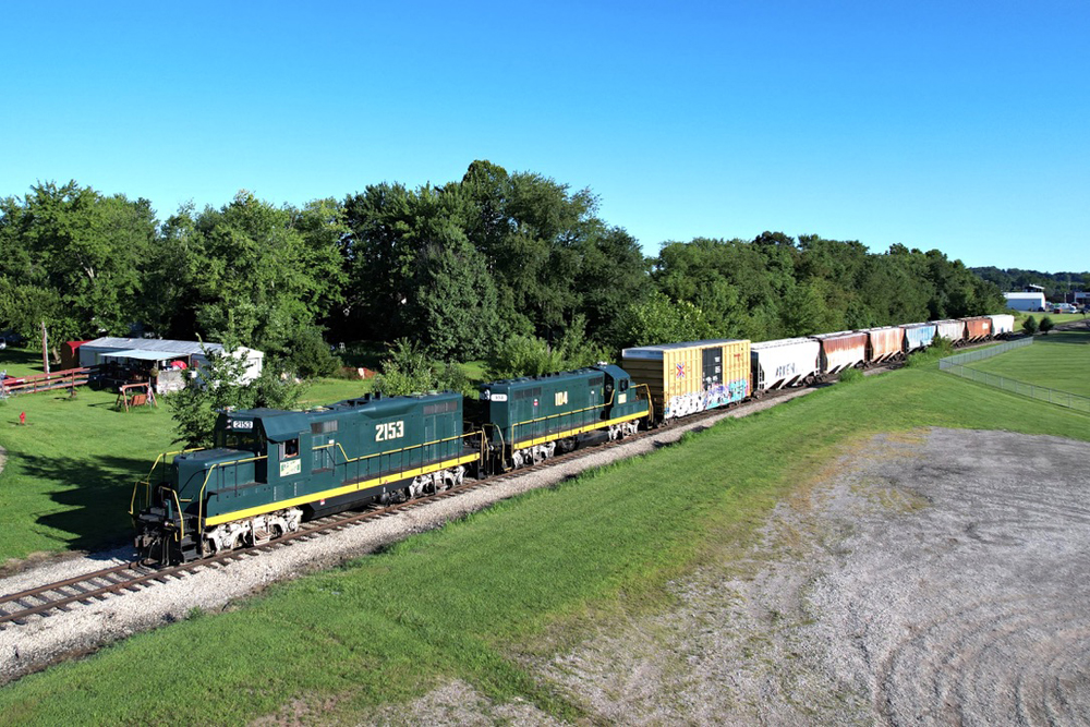 Two green locomotives with freight train