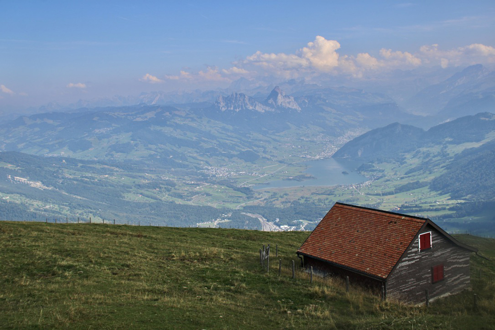 Mountains in distance with barn on hillside in foreground