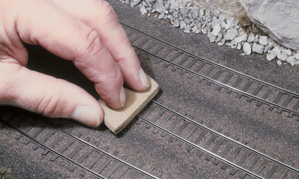 A cleaning block is used to scrub the railhead of HO scale rail