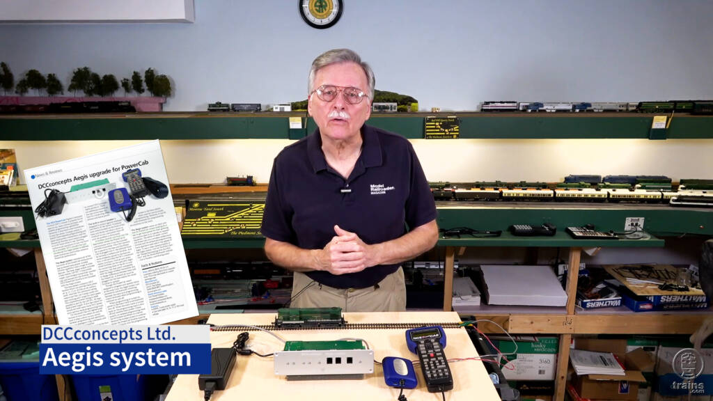Screen capture of a man standing in front of a model railroad introducing a product review video.