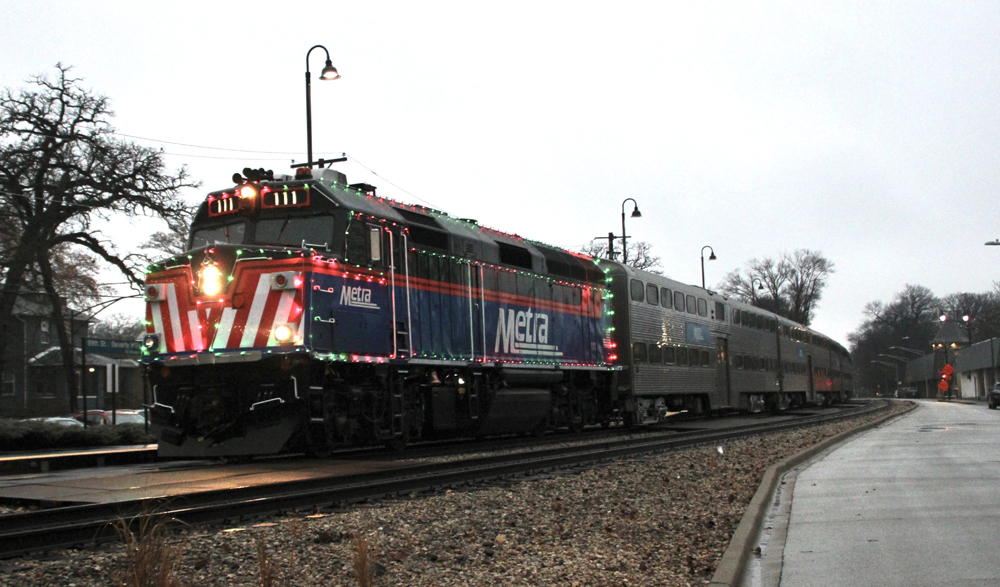 Commuter train with locomotive decorated with holiday lights