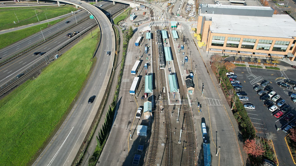 Aerial view of light rail station at junction, surrounded by bus bays