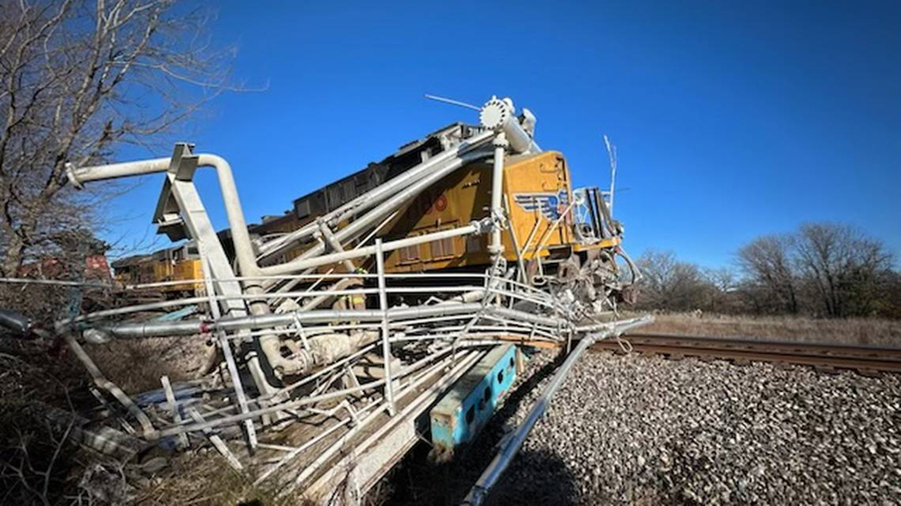 Derailed locomotive tangled in debris from collision