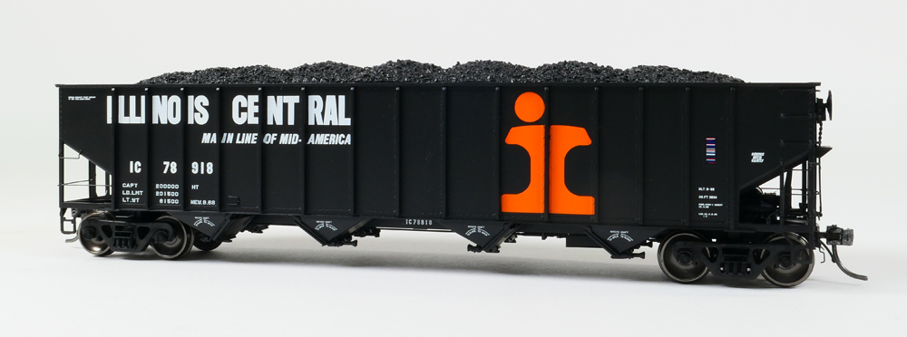 Color photo of HO scale hopper painted black with orange and white graphics.