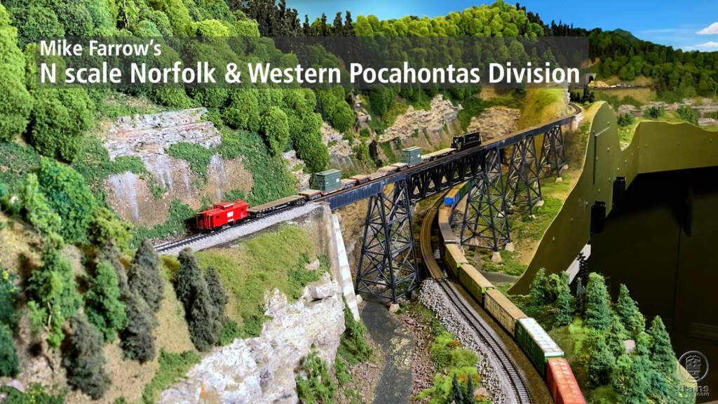 Title screen from video showing train on bridge passing over train below.