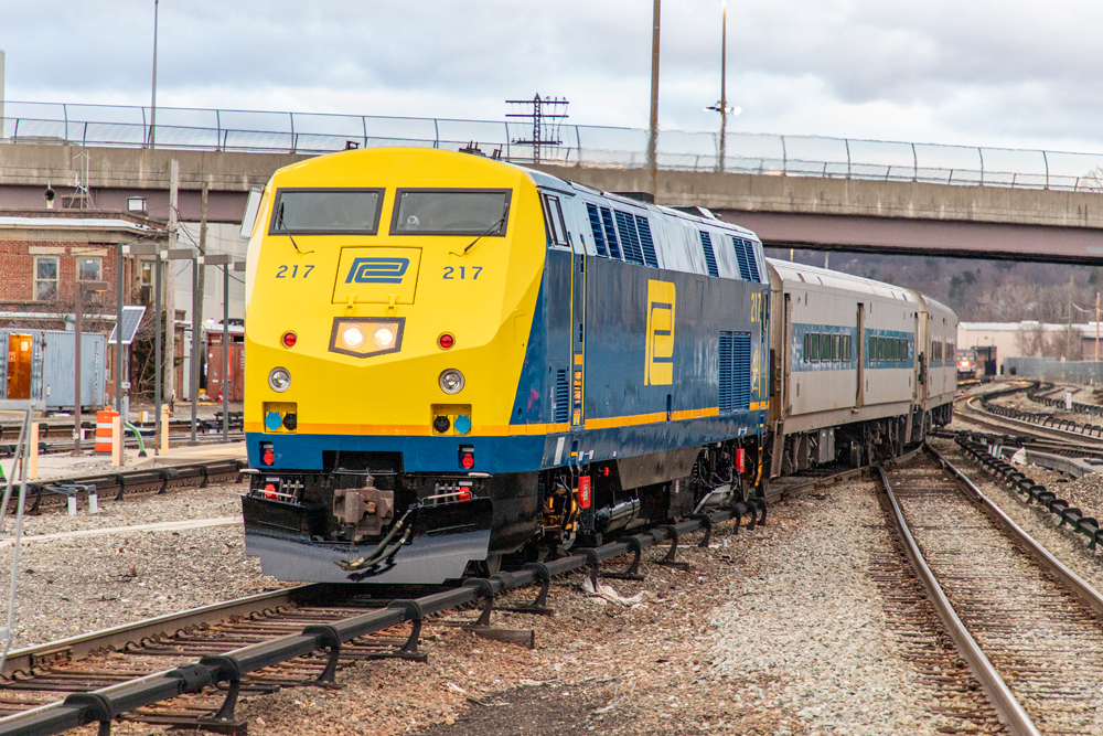 Blue locomotive with yellow nose on commuter train
