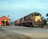 Diesel Rock Island locomotives on freight train by station
