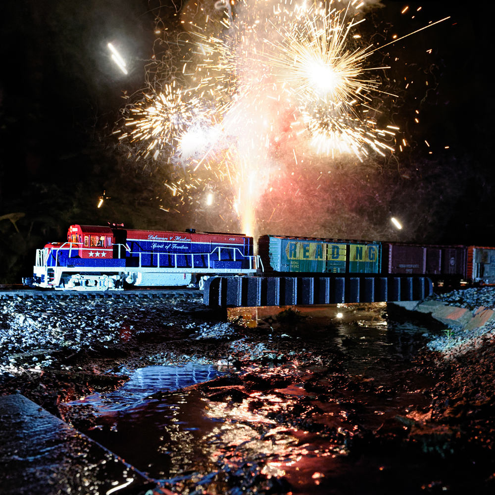 Model train with fireworks behind it