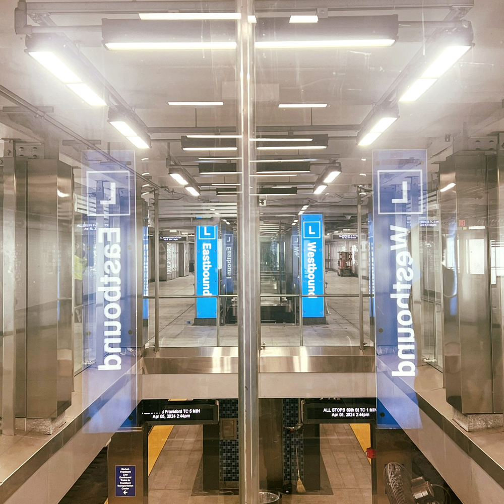 View of station through glass with bright lighing and informational banners