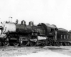 Steam locomotive in profile with passenger train