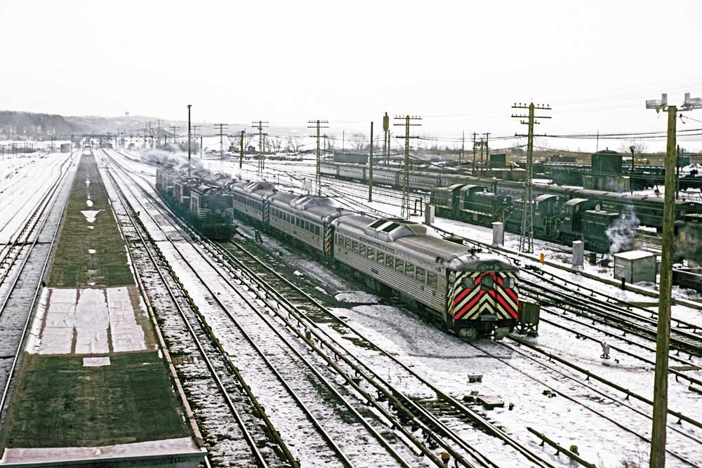 Railroad equipment in snow-dusted yard along river as photographed with color Kodachrome slides