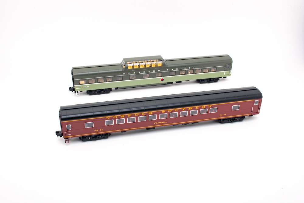 Two o-scale passenger cars sitting next to each other