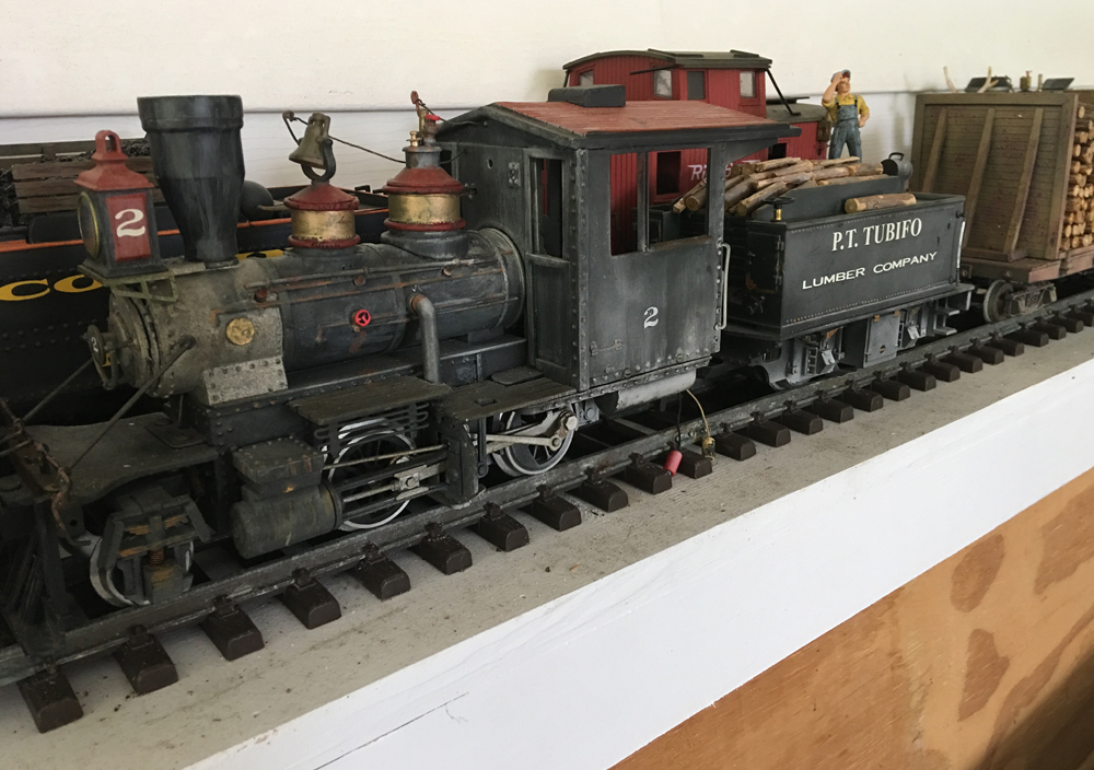 model steam locomotive with car behind it