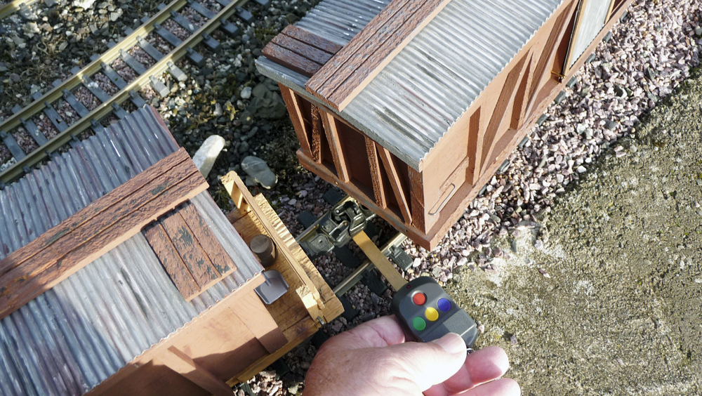 hand with tool next to model buildings