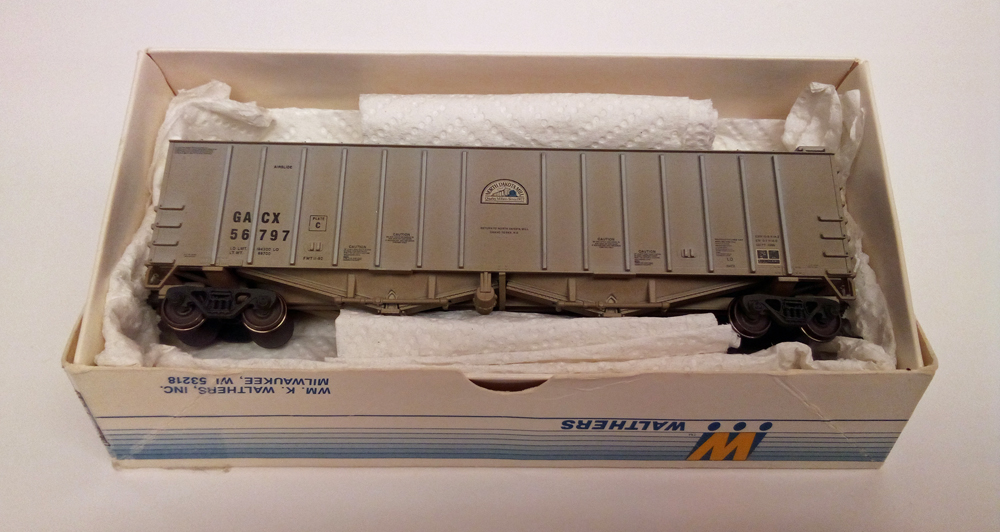 Color photo of weathered HO freight car in box with paper towel lining box.
