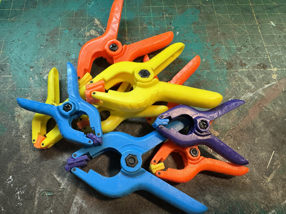 Color image of plastic spring clamps on workbench mat.