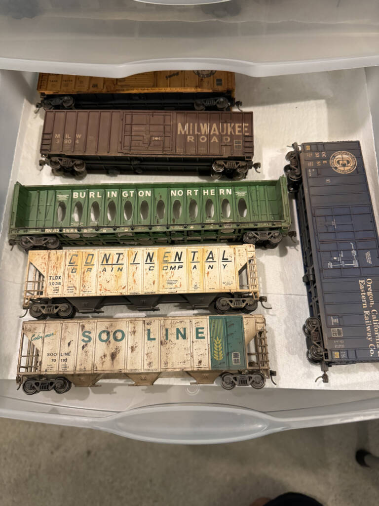 Color photo showing plastic drawer lined with paper towels and six HO scale freight cars.