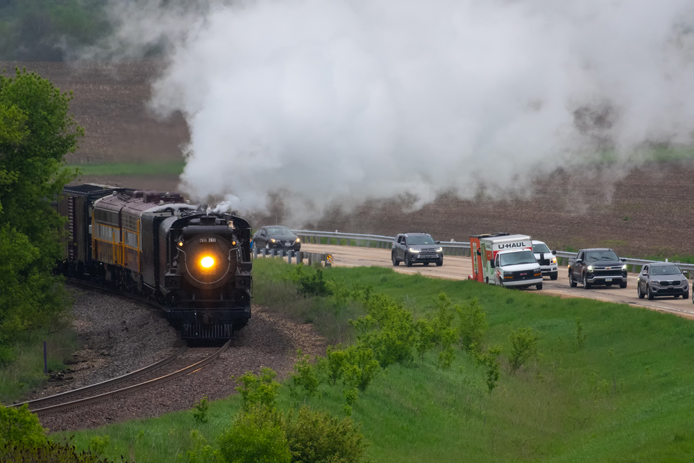 steam with train and cars on side of it