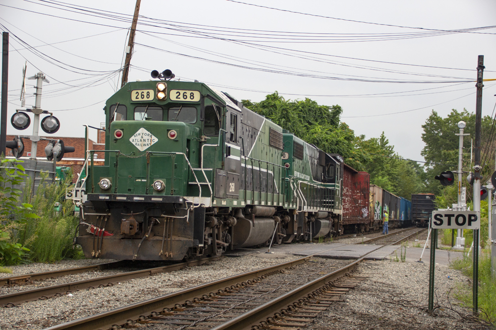 Green and black locomotives with freight train