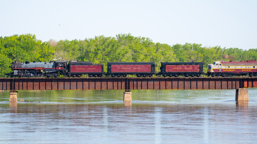 Steam locomotive and water tenders on bridge