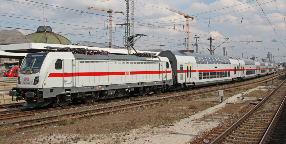 White locomotive and bilevel passenger cars with red center stripe