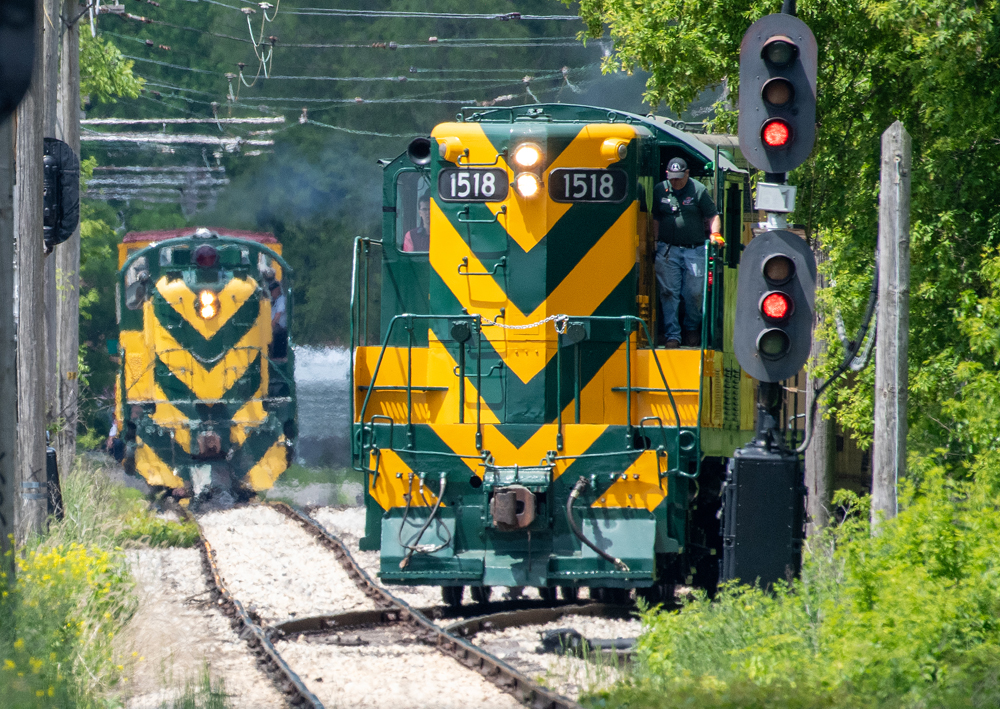 Two green and yellow diesels meet