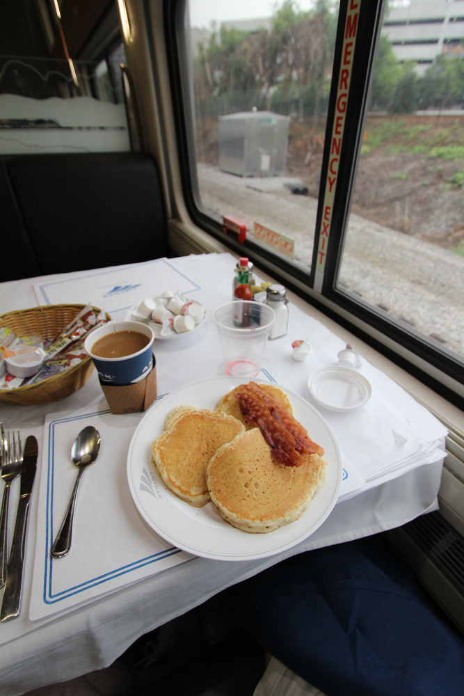Food on table of dining car with view outside clearly visible