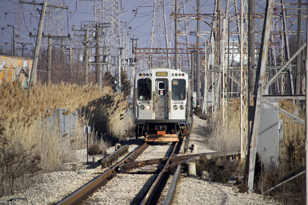 Rapid transit train on line surrounded by power lines