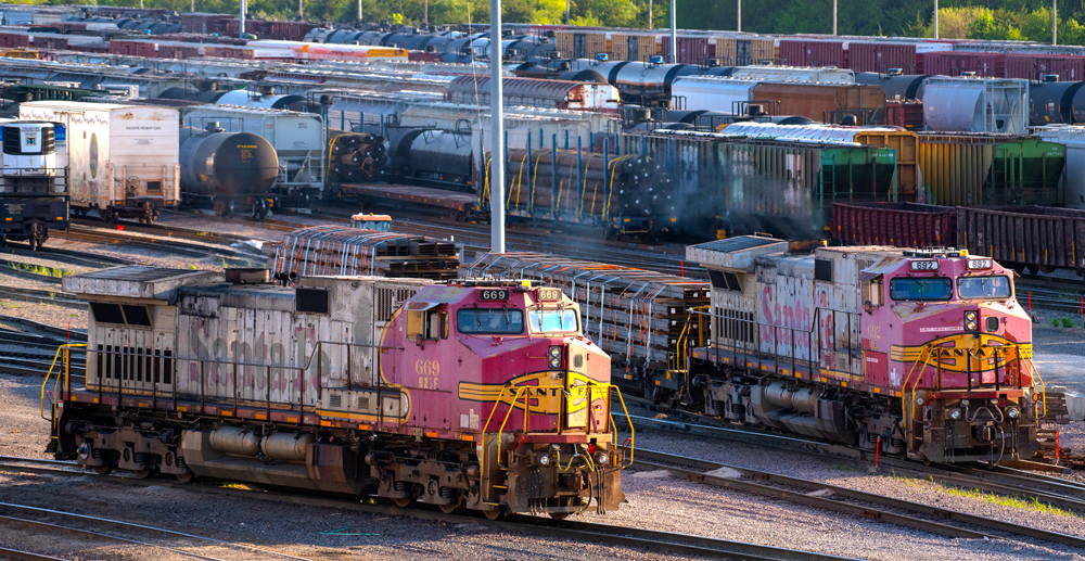 Battered red-and-silver diesel locomotives on yard tracks