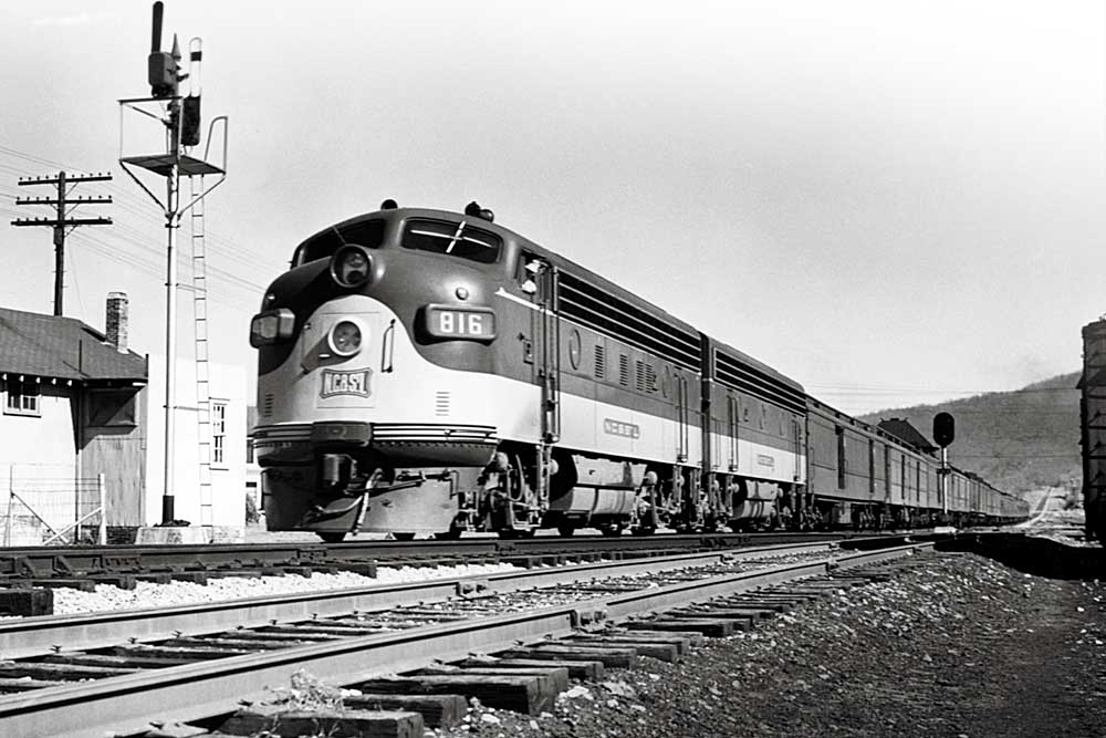 Diesel NC&StL locomotives with passenger train by signal and station