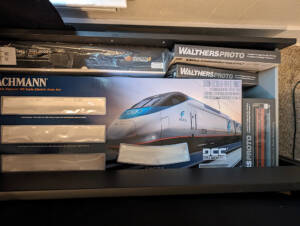 Open drawer with boxed rolling stock and Acela train set.