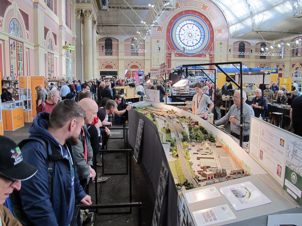 Crowds observing a model railroad layout during a big train show.
