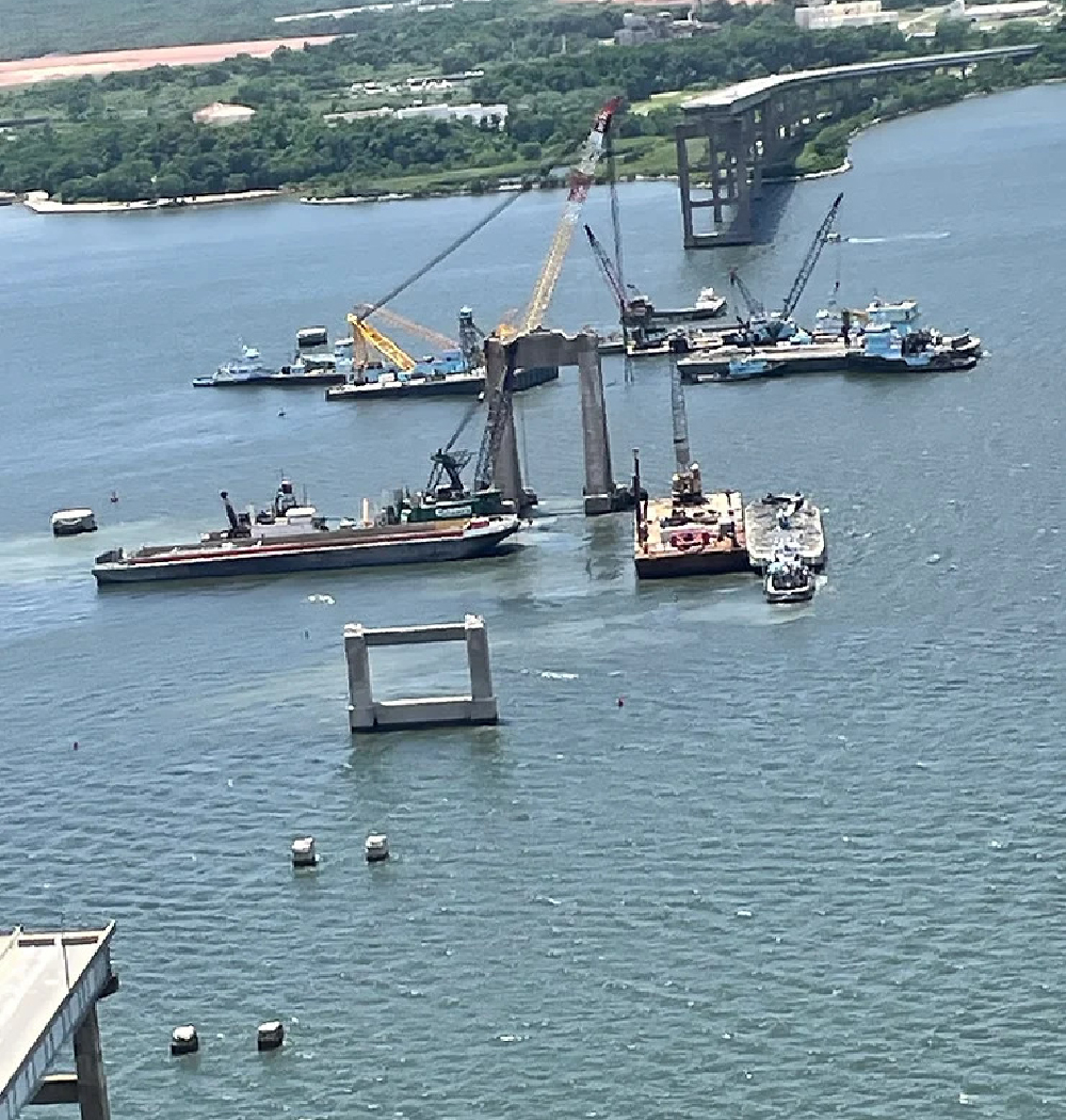 Barges with cranes cleanup bridge collapse. 