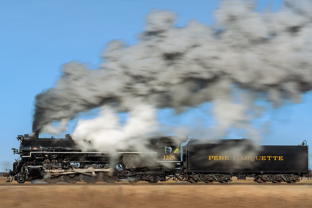 Pan shot of steam locomotive across a field
