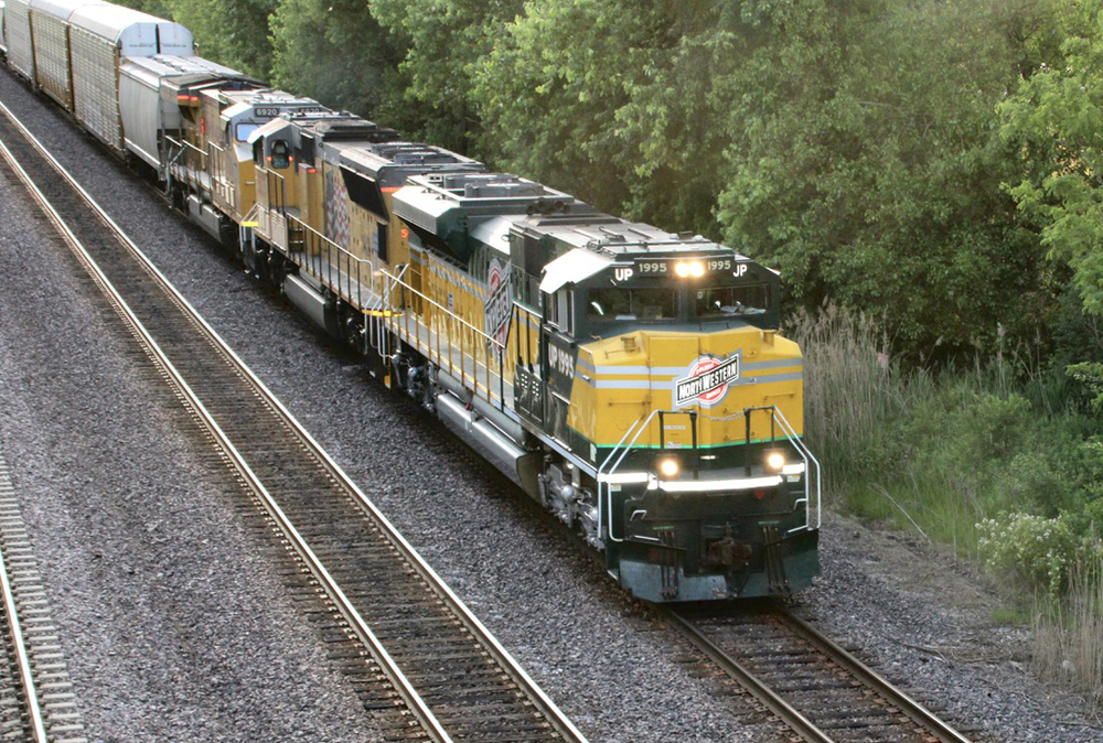 Green and yellow locomotive leading freight train