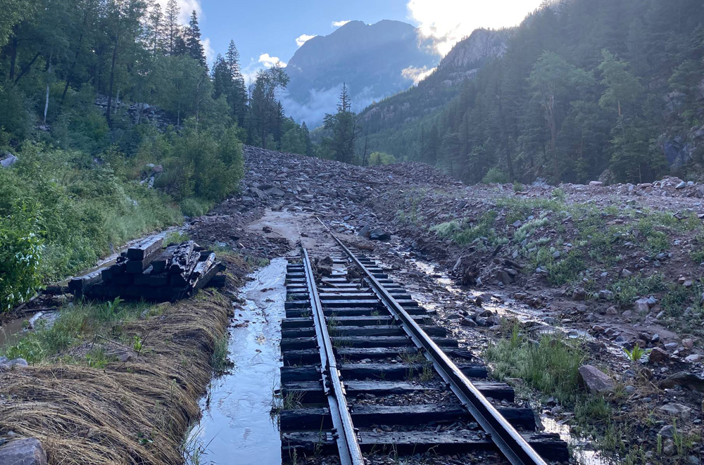 View of rock slide in mountains blocking railroad trains