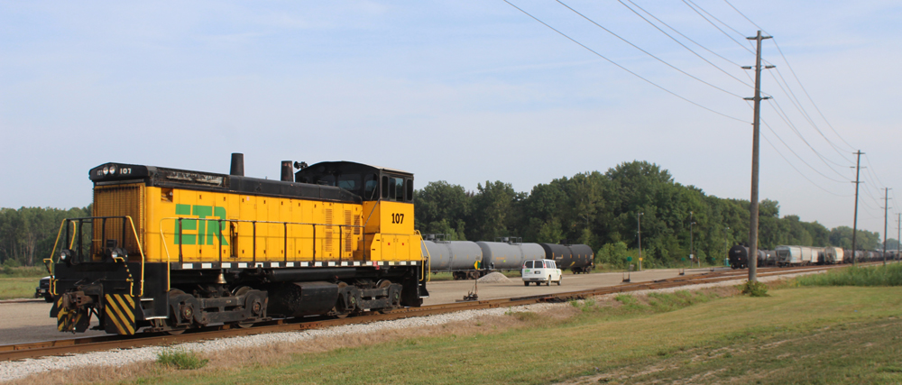 Yellow and black end-cab switcher stopped on rail line