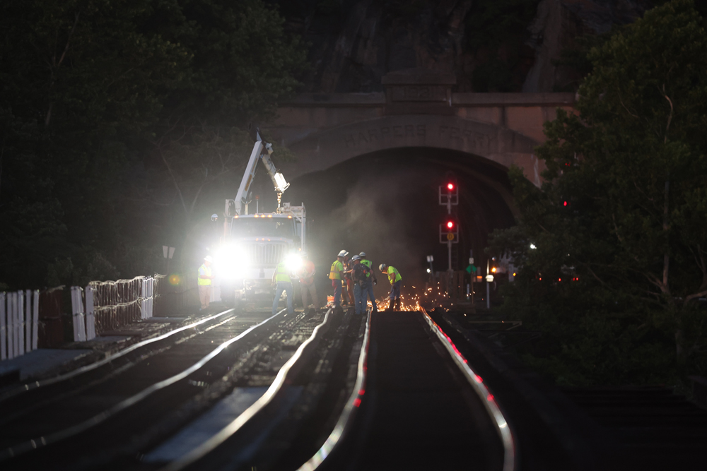 Hi-rail vehicle and workers on bridge at night