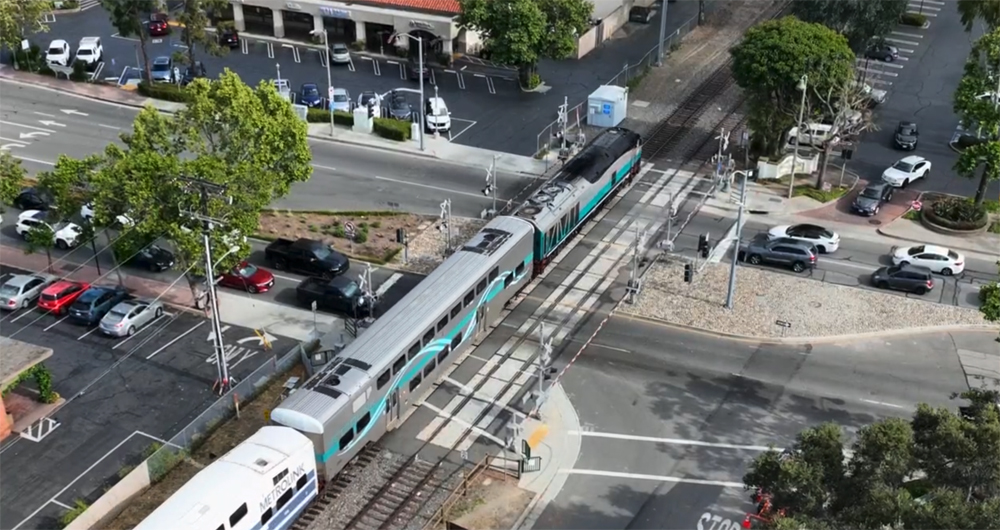 Aerial view of commuter train at grade crossing